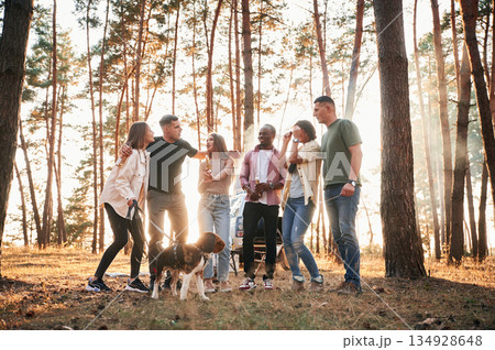 Full height photo, standing with dog. Group of friends are together in the forest 134928648