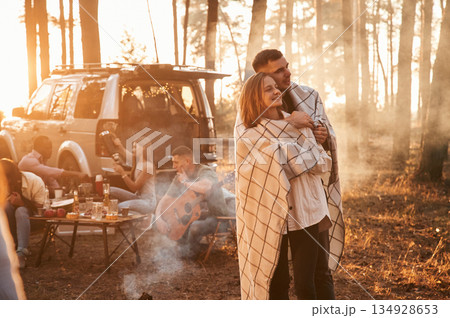 Lovely couple embracing each other, in smoke. Group of friends are together in the forest 134928653