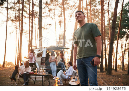 Adult man is standing. Group of friends are together in the forest 134928676
