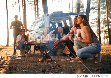 Time for preparing marshmallows on bonfire. Group of friends are together in the forest 134928866
