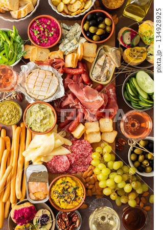 This festive spread features an array of cheese, cured meats, hummus, nuts, and fresh vegetables. Perfect for sharing at a casual get-together or celebration with friends 134928925