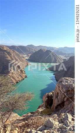 Emerald River Winding Through Rugged Canyon, Steep Slopes Framing Vibrant Turquoise Water, Panoramic Viewpoint Perfect For Hikers And Kayakers, Crisp Light Revealing Raw Geological Layers 134929281