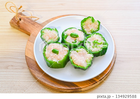 輪切りにした焼く前のピーマンの肉詰め 134929588