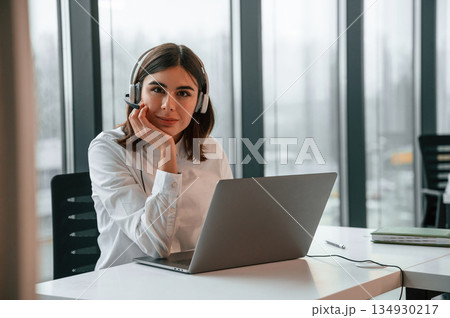 Beautiful young woman is working in the office by laptop Beautiful young woman is working in the office by laptop 134930217