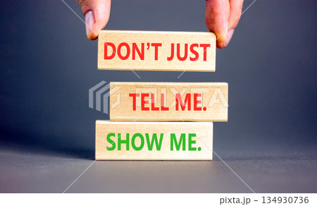 Tell or show symbol. Concept words Do not just tell me, show me on beautiful wooden blocks. Beautiful grey background. Businessman's hand. Business tell or show concept. Copy space. 134930736