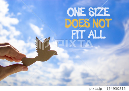One size does not fit all symbol. Concept words One size does not fit all on beautiful sky. Beautiful blue sky background. Businessman's hand. Business one size does not fit all concept. Copy space. 134930813