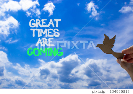 Great times are coming symbol. Concept words Great times are coming. Beautiful blue sky and clouds background. Businessman hand with wooden bird. Business great times are coming concept. Copy space. Great times are coming symbol. Concept words Great times are coming. Beautiful blue sky and clouds background. Businessman hand with wooden bird. Business great times are coming concept. Copy space. 134930815