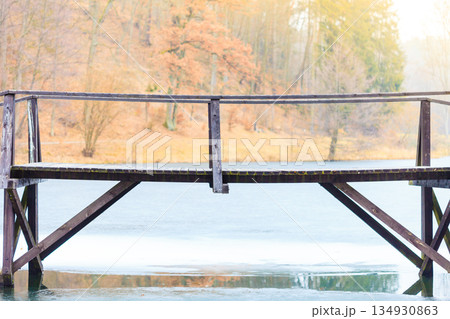 Old, wooden, small bridge on frozen lake 134930863