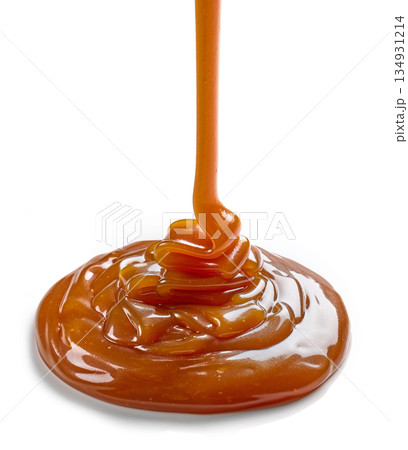 caramel sauce pouring on white background caramel sauce pouring on white background 134931214