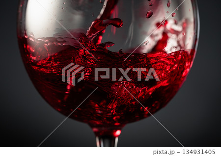 Red wine of rich dark color being poured into a glass. Red wine of rich dark color being poured into a glass. 134931405
