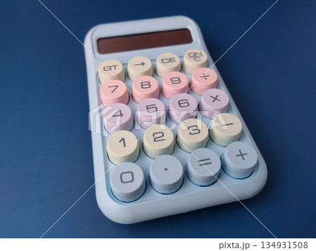 Top view pastel-colored desktop calculator featuring a retro typewriter style with large, round mechanical keys. 134931508