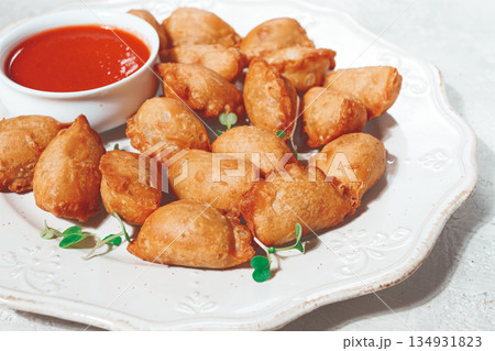 Fried mini chebureks, with sauce, on a decorative plate, hard light, no people, 134931823