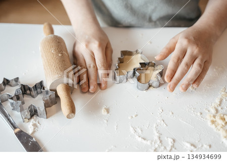 Homemade Christmas Cookies In Preparation: Hands Kneading Dough, Cutting Shapes, And Decorating Biscuits With Chocolate In Cozy Kitchen Atmosphere 134934699