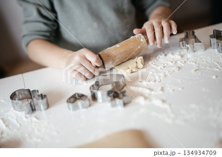 Homemade Christmas Cookies In Preparation: Hands Kneading Dough, Cutting Shapes, And Decorating Biscuits With Chocolate In Cozy Kitchen Atmosphere 134934709