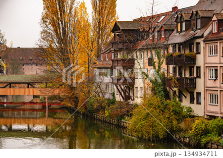 Historic Bridge And Medieval Architecture In Nuremberg: Traditional Half-Timbered Houses Reflected In Calm River Water On An Overcast Autumn Day 134934711