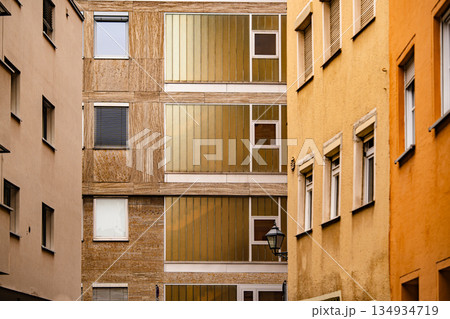 Modern Residential Architecture In Nuremberg: Narrow Urban Alley With Colorful Facades And Geometric Window Patterns Creating A Contemporary City Aesthetic 134934719