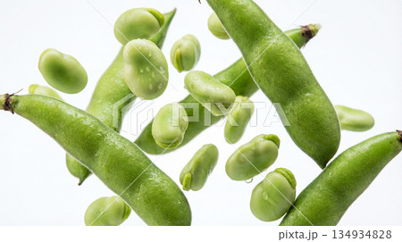 Fresh and tasty broad beans falling on white background Fresh and tasty broad beans falling on white background 134934828