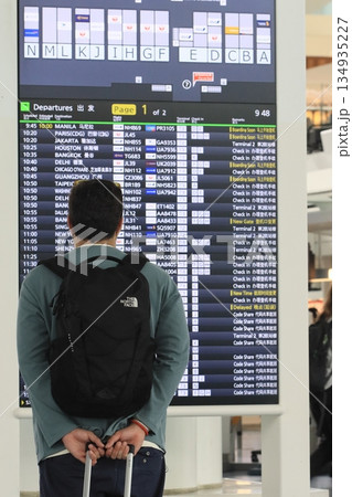 フライトの時刻表を確認する旅行客　飛行機の時刻表 134935227