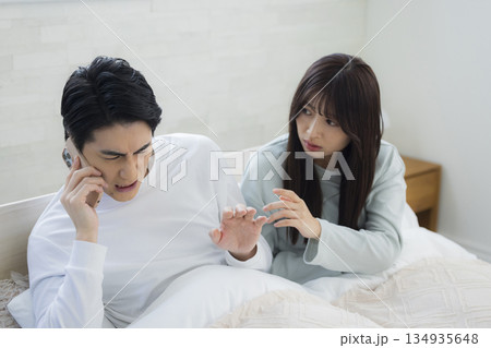 ベッドでスマホを見るカップル 134935648