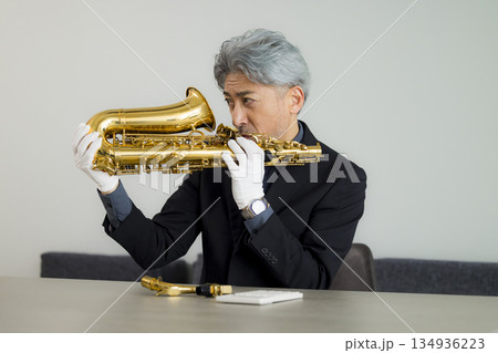 サックスを買取査定する男性 134936223