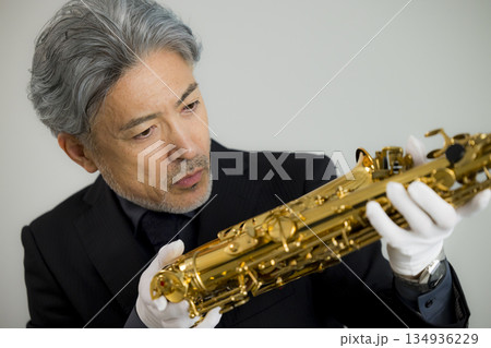 サックスを買取査定する男性 134936229