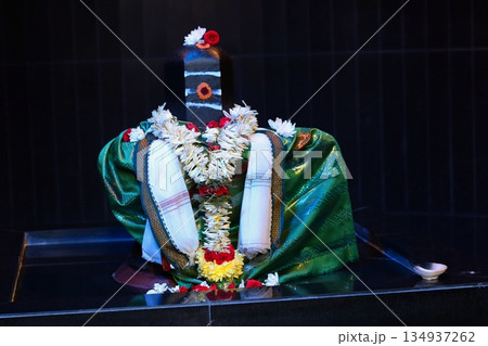 Hindu Shiva lingam inside a Kuala Lumpur, Malaysia temple, decorated with flowers, symbolizing spirituality and religious devotion. Hindu Shiva lingam inside a Kuala Lumpur, Malaysia temple, decorated with flowers, symbolizing spirituality and religious devotion. 134937262