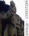 Close-up of a large Hindu deity statue at Batu Caves, Malaysia, emphasizing religious symbolism, stone texture, and cultural heritage. 134937284