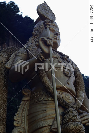 Close-up of a large Hindu deity statue at Batu Caves, Malaysia, emphasizing religious symbolism, stone texture, and cultural heritage. Close-up of a large Hindu deity statue at Batu Caves, Malaysia, emphasizing religious symbolism, stone texture, and cultural heritage. 134937284