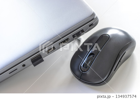 ワイヤレスマウスと、ノートパソコンに差し込まれたUSBレシーバー ワイヤレスマウスと、ノートパソコンに差し込まれたUSBレシーバー 134937574