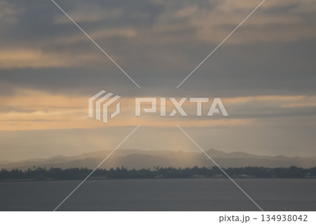 海と雲の多い空と薄明光線と対岸の海岸と森と霞む山の風景 134938042