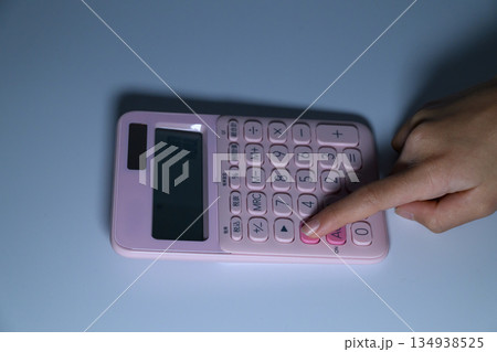 電卓を指で操作する女性の手元のアップ 電卓を指で操作する女性の手元のアップ 134938525