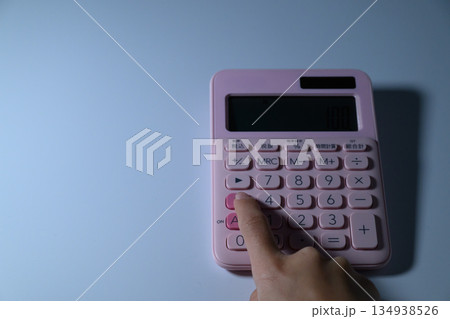ピンクの電卓を操作する女性の指先 ピンクの電卓を操作する女性の指先 134938526