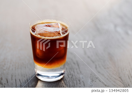 Espresso tonic with clear ice cube in tumbler glass on oak wood table with copy space Espresso tonic with clear ice cube in tumbler glass on oak wood table with copy space 134942805