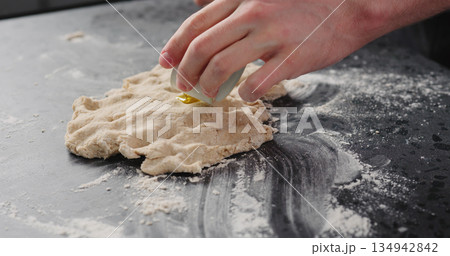 man add olive oil to dough on concrete countertop man add olive oil to dough on concrete countertop 134942842