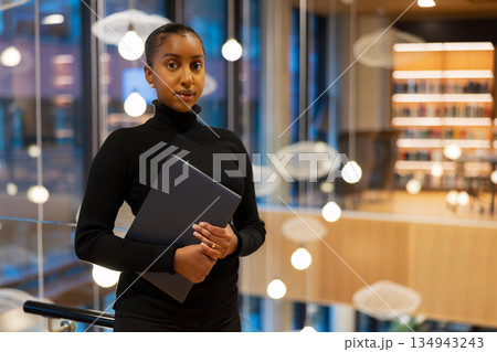 Confident student in modern library 134943243