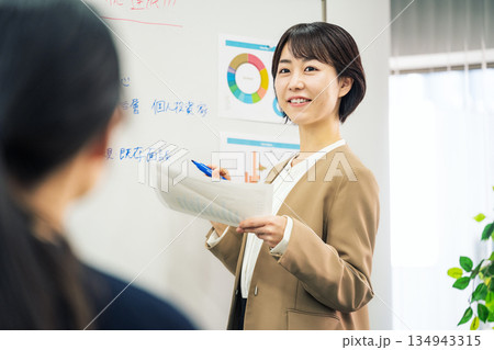 会社の営業会議で説明をする若い女性 134943315