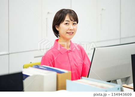 オフィスでデスクワークをするポロシャツ姿の若い女性 134943609
