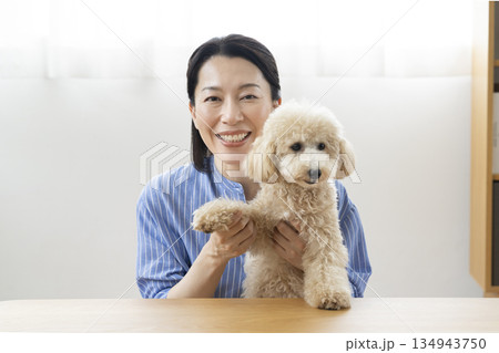 カメラ目線で話す50代の女性と愛犬 カメラ目線で話す50代の女性と愛犬 134943750