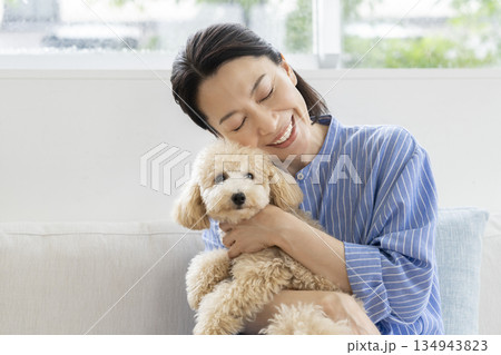 愛犬を抱くミドル女性 134943823