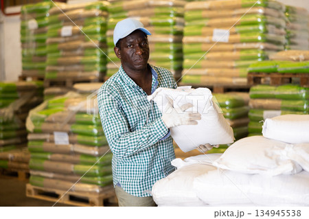 Positive African American worker loading sacks 134945538