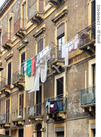 Drying laundry hanging on balconies of old building in catania Drying laundry hanging on balconies of old building in catania 134946402