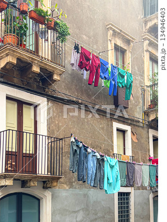 Clothes hanging on lines between old buildings 134946403