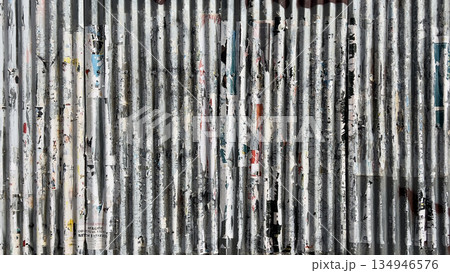 Corrugated metal wall with peeling urban posters and texture 134946576