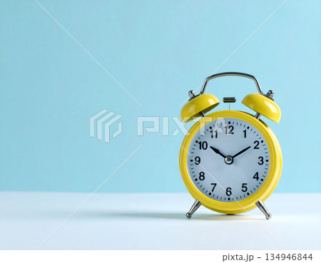 Minimalist decor. Yellow metal alarm clock with yellow bells on pastel blue background. 134946844