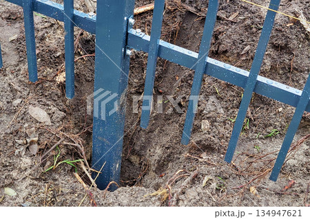 Fence installation. Digging a hole for metal fence posts. Fence installation. Digging a hole for metal fence posts. 134947621