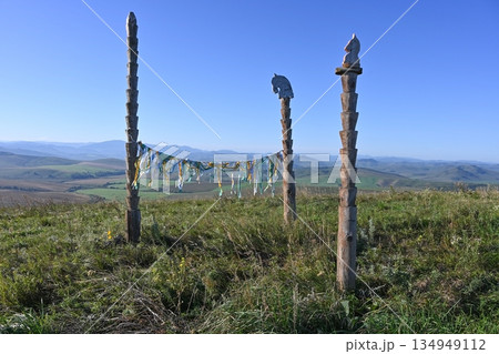 Ceremonial sacred ribbons are tied to wooden poles against a blue sky background 134949112