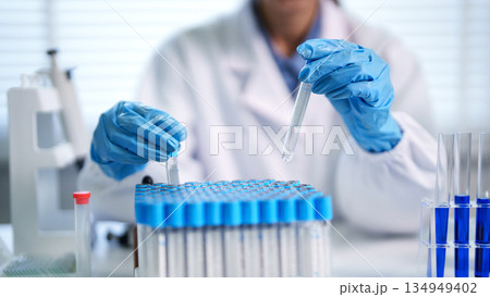 Scientist adult hands conduct chemical experiment with test tubes professional laboratory research medical analysis developing innovation scientific discovery 134949402