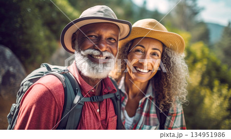 Middle aged couple walking on forest path with backpacks in summer 134951986