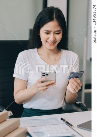 Online payment, Hands of woman holding a credit card and using smart phone for online shopping 134953374