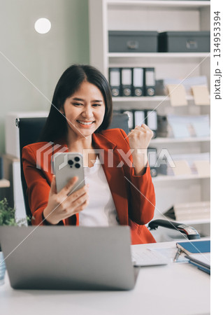 Asian business woman working on a laptop in a professional office Asian business woman working on a laptop in a professional office 134953394